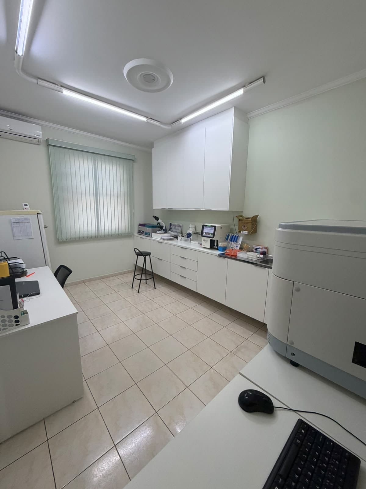 Sala do laboratório do AMA Diagnóstico Animal, com bancada, microscópio e equipamentos de análise
